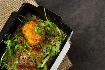 Fish hake baked with tomato sauce, quinoa and arugula. Healthy food, restaurant dish delivery. Top view. Free space for your text. Dark background.