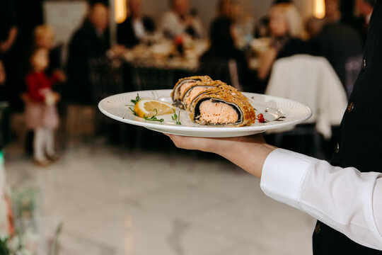 Waiter Serving Food In Restaurant