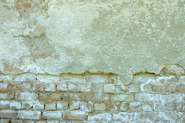 Gray plastered old brickwall with chipped stucco pieces. Grunge white brick wall with damaged surface background