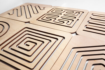 Wooden finger labyrinths on white background, closeup. Montessori toy