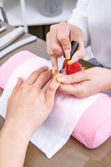manicurist's hands, painting her client's nails with permanent nail polish. High quality photo