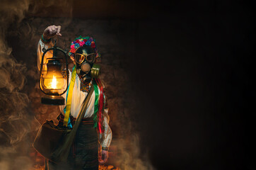 Ukrainian woman in a gas mask lights the way with an old gas lamp. Traditional folk costume. They hide in the basement, bomb shelters from chemical attacks, with poisonous gases. Copy space.