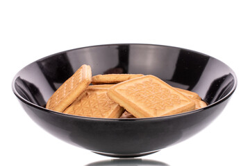 Several delicious sugar cookies in a black ceramic plate, macro, isolated on a white background.