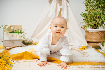 child in a white house with tent and spring flowers