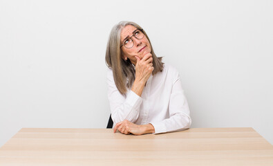 senior  gray hair woman thinking, feeling doubtful and confused. desk and business concept