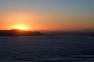 View of a spectacular sunset and a cruise ship from the rooftops of Fira Santorini Greece
