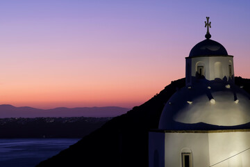 View of a traditional Greek church in Santorini and an amazing purple sunset - obrazy, fototapety, plakaty