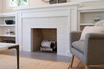 Fireplace with painted white flower pattern facing and white wood mantel and bookcases.