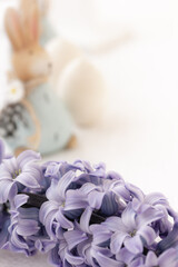Macro of lilac blooming hyacinth flower and Easter rabbits, eggs on blurred background. Easter decor