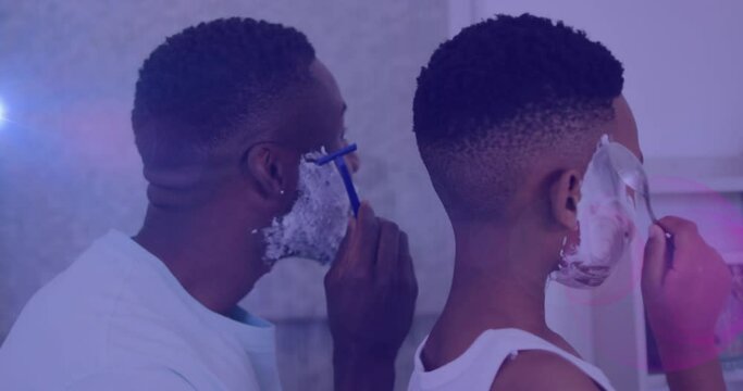 Animation of lights over back of african american father and son shaving beards