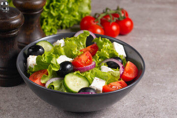 Greek salad with fresh tomatoes, cucumber, olives, feta cheese and red onion. Healthy and diet food concept.
