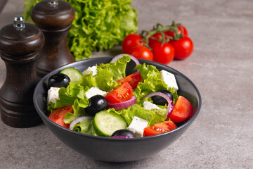 Greek salad with fresh tomatoes, cucumber, olives, feta cheese and red onion. Healthy and diet food concept.