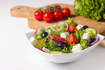 Greek salad with fresh tomatoes, cucumber, olives, feta cheese and red onion. Healthy and diet food concept.
