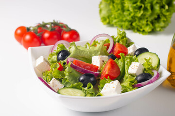 Greek salad with fresh tomatoes, cucumber, olives, feta cheese and red onion. Healthy and diet food concept.