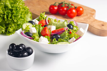 Greek salad with fresh tomatoes, cucumber, olives, feta cheese and red onion. Healthy and diet food concept.
