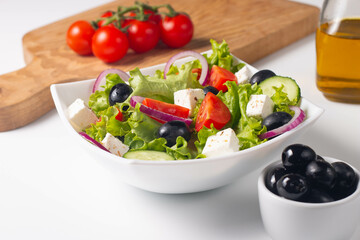 Greek salad with fresh tomatoes, cucumber, olives, feta cheese and red onion. Healthy and diet food concept.