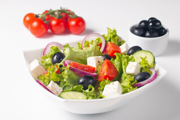 Greek salad with fresh tomatoes, cucumber, olives, feta cheese and red onion. Healthy and diet food concept.