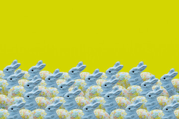 Easter bunnies with eggs. Easter decoration on a yellow background.