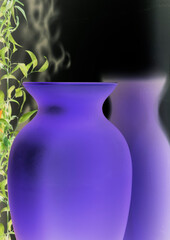 blue vase reflected from black mirror wall with small plant in the background
