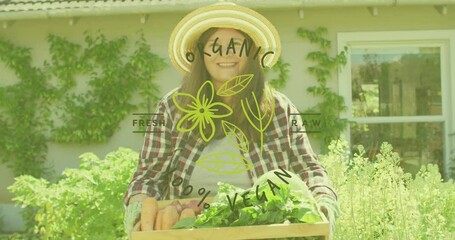 Animation of organic vegan text in green letters over caucasian woman holding tray with vegetables