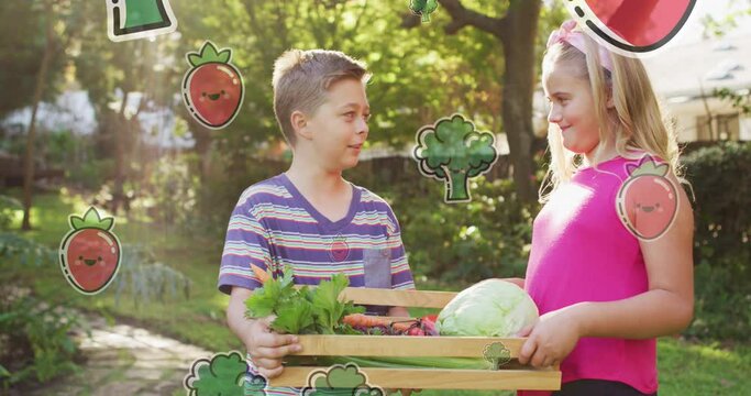 Animation of fruit and vegetables icons over happy caucasian siblings with box of vegetables