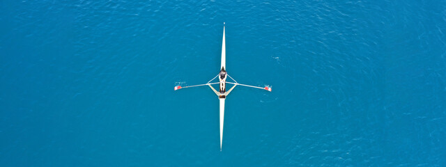 Aerial drone ultra wide top down panoramic photo with copy space of sport canoe operated by young woman in deep blue calm sea waters © aerial-drone