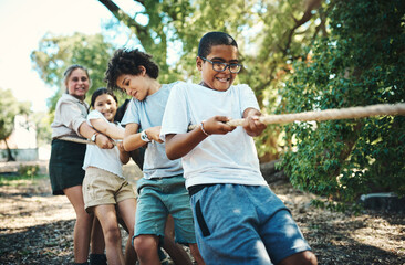 Were all winning when were playing together. Shot of a group of teenagers playing a game of tug of war at summer camp. - obrazy, fototapety, plakaty