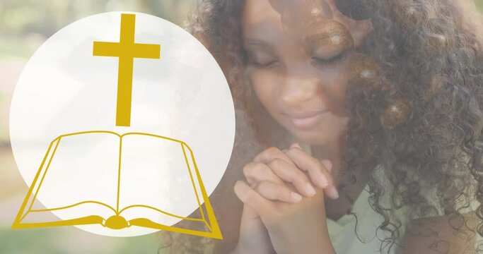 Animation of bible icon over african american woman praying