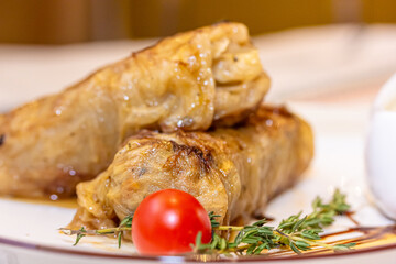 Stuffed cabbage rolls with meat on a plate with sour cream