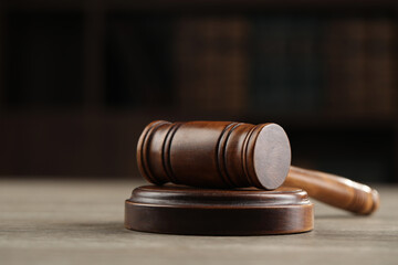 Wooden gavel on table against dark background, closeup