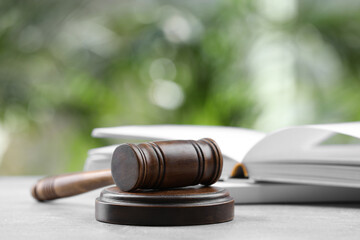 Wooden gavel on grey table against blurred background