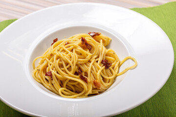 Italian delicious spaghetti carbonara pasta with bacon parmesan lies in a plate