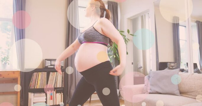 Animation of colourful spots over caucasian pregnant woman exercising at home