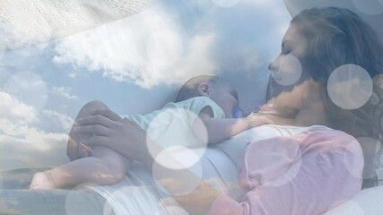 Animation of clouds over caucasian mother sleeping with her baby