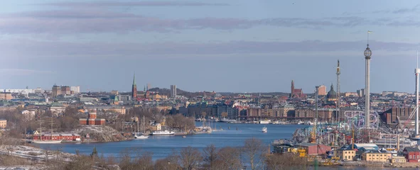 Fotobehang Panorama view over the Stockholm down town bays with castle, amusement park, boats and apartment houses a snowy spring day in Stockholm © Hans Baath