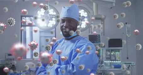 Animation of covid 19 cells over smiling african american male surgeon - Powered by Adobe