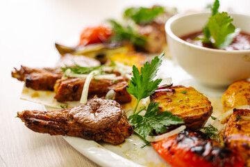 caucasian barbecue with meat on coals and baked vegetables, close-up
