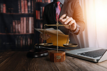 Business and lawyers discussing contract papers with brass scale on desk in office. Law, legal services, advice, justice and law concept picture with film grain effect
