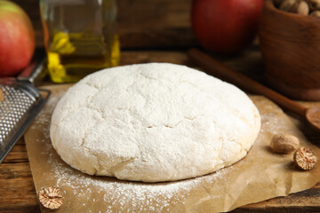 Raw dough for pastry on wooden table, closeup