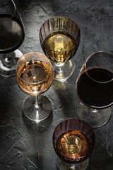 Glasses with  red ,white  and rose wine on black marble background. View above.  Copy space.