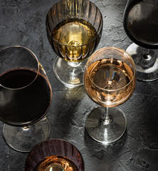 Glasses with  red ,white  and rose wine on black marble background. View above.  Copy space.