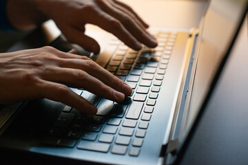 hands of a man working on a laptop, close-up