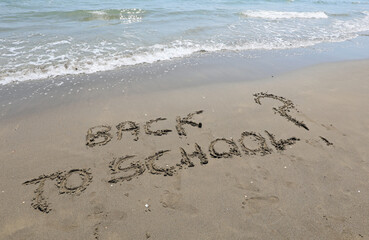 big text BACK TO SCHOOL and question mark on the beach