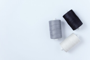 Three spools of sewing thread. Place text. White background.