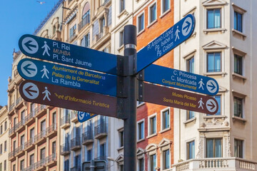 Street signs marking the direction to the famous sites to visit in Barcelona, Spain - 498351556