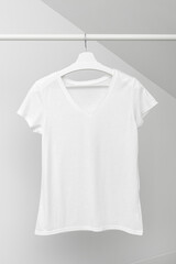 Group of Assorted t-shirts hanging on white hangers. Clothing rack