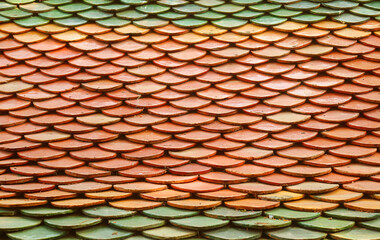 Orange and Green Colored Glazed Roof Tiles of Buddhist Temple in Thailand