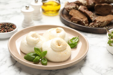 Delicious burrata cheese with basil on white marble table