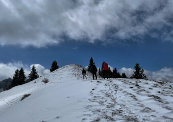 Drei Wanderer mit Rucksack von hinten im Schnee auf dem Weg zum Gipfel des Erlbergkopf, Alpen,...