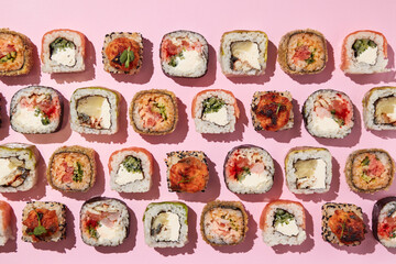 Various sushi rolls on pink background, top view. - 498356179